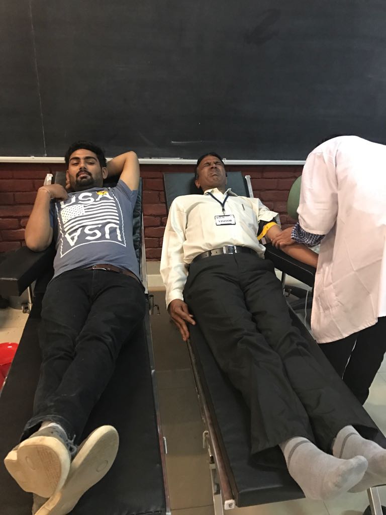 Student and Security Staff donating blood.